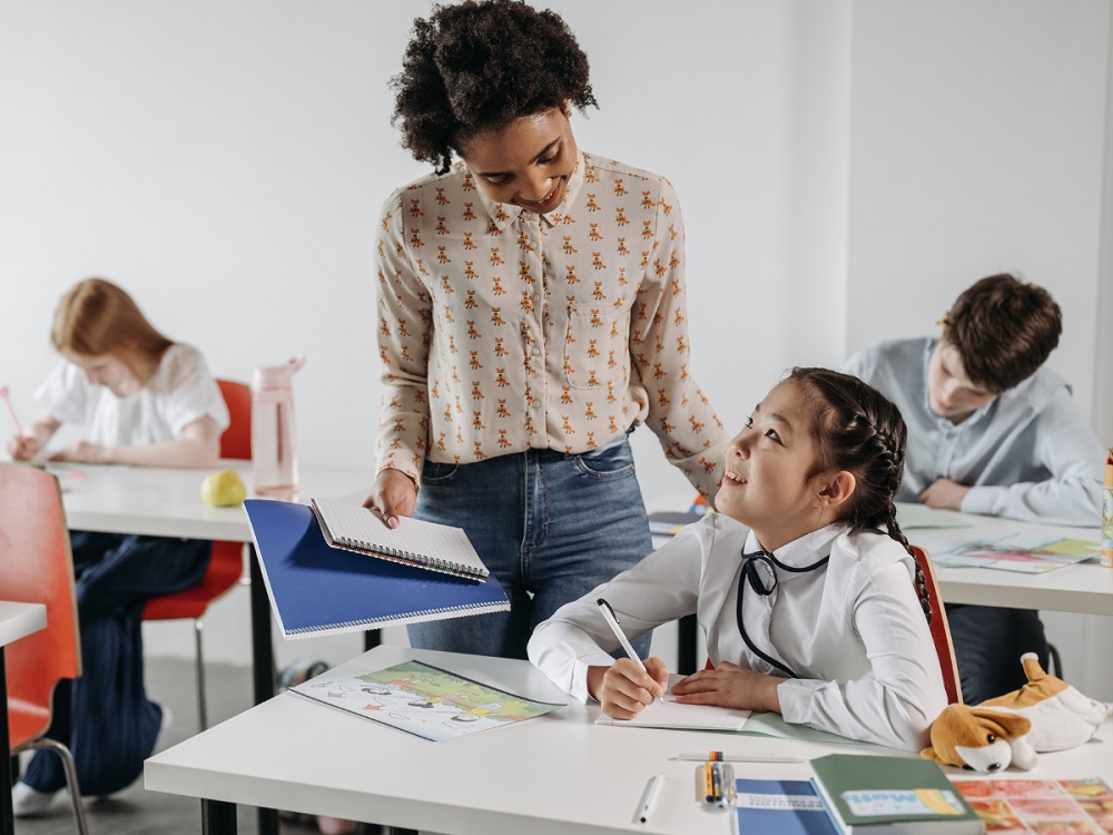 Web – Teacher helping little girl student