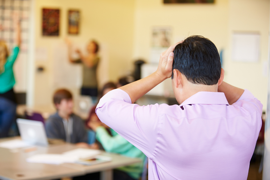 Staying Positive Article (2) Frustrated male teacher holds his head in exasperation