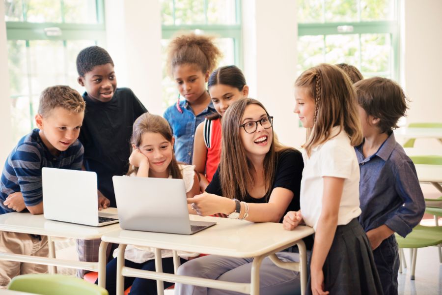 Conferences-900×600 Students gather around teacher