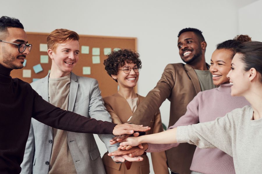 Group of teachers with hands in center like a team