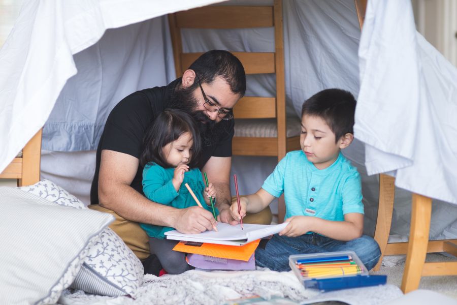 Self-Management-900×600 A father sits with his kids in a homemade fort