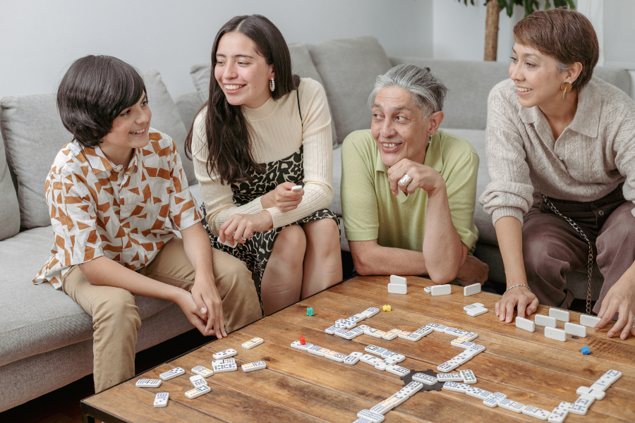 Social Awareness-900×600 Multi-generational family plays a game of dominos together
