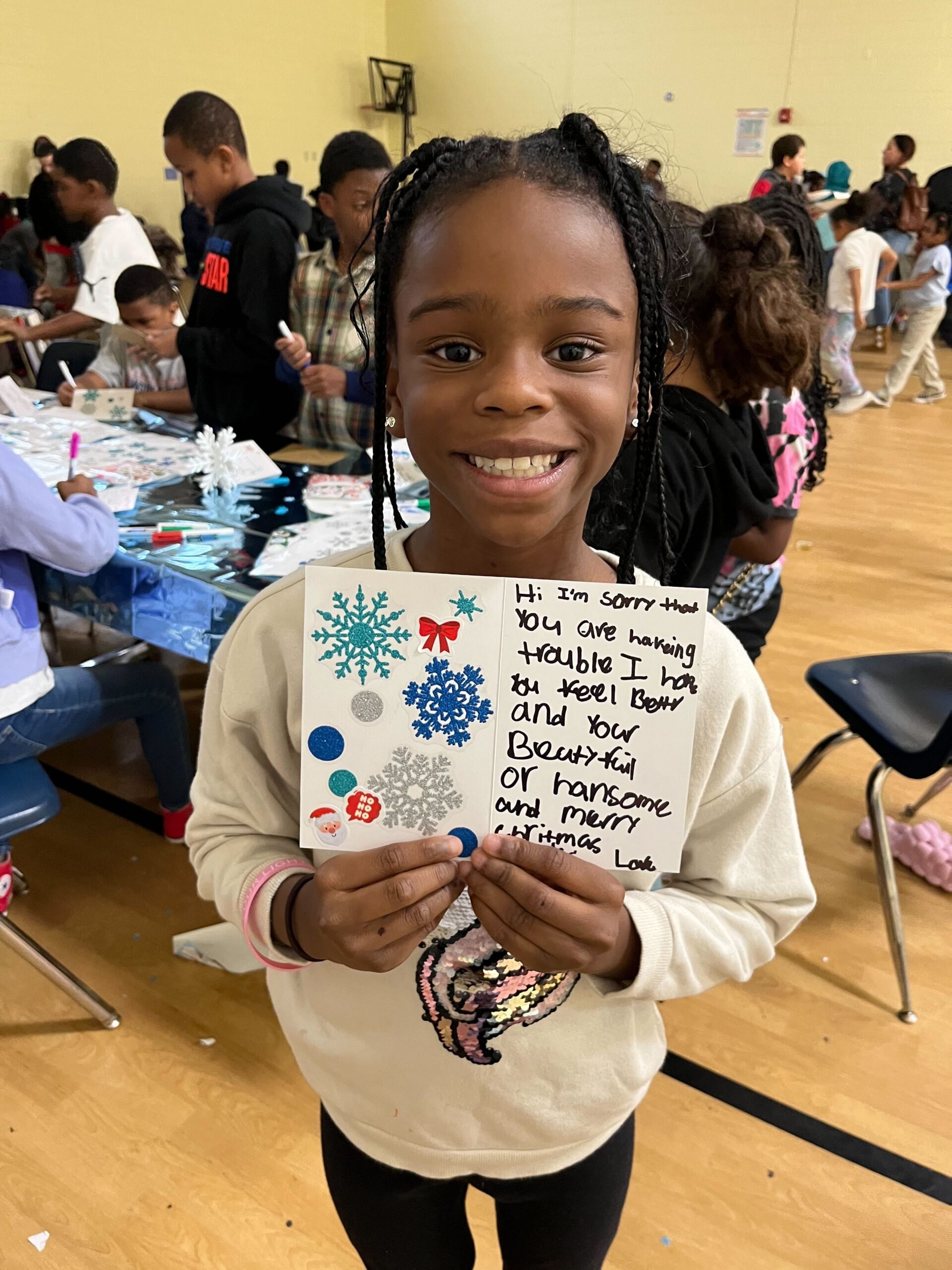 Child proudly holds a card she made