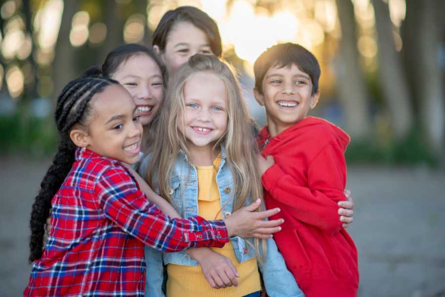 diverse kids hug each other