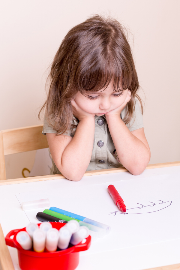 Little girl holds head in her hands