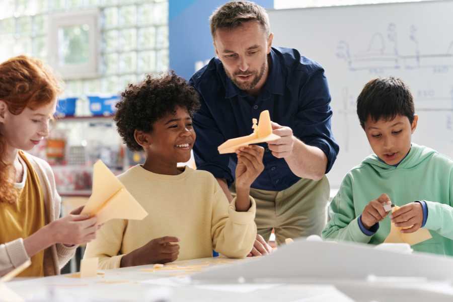 Teacher shows students how to build airplane