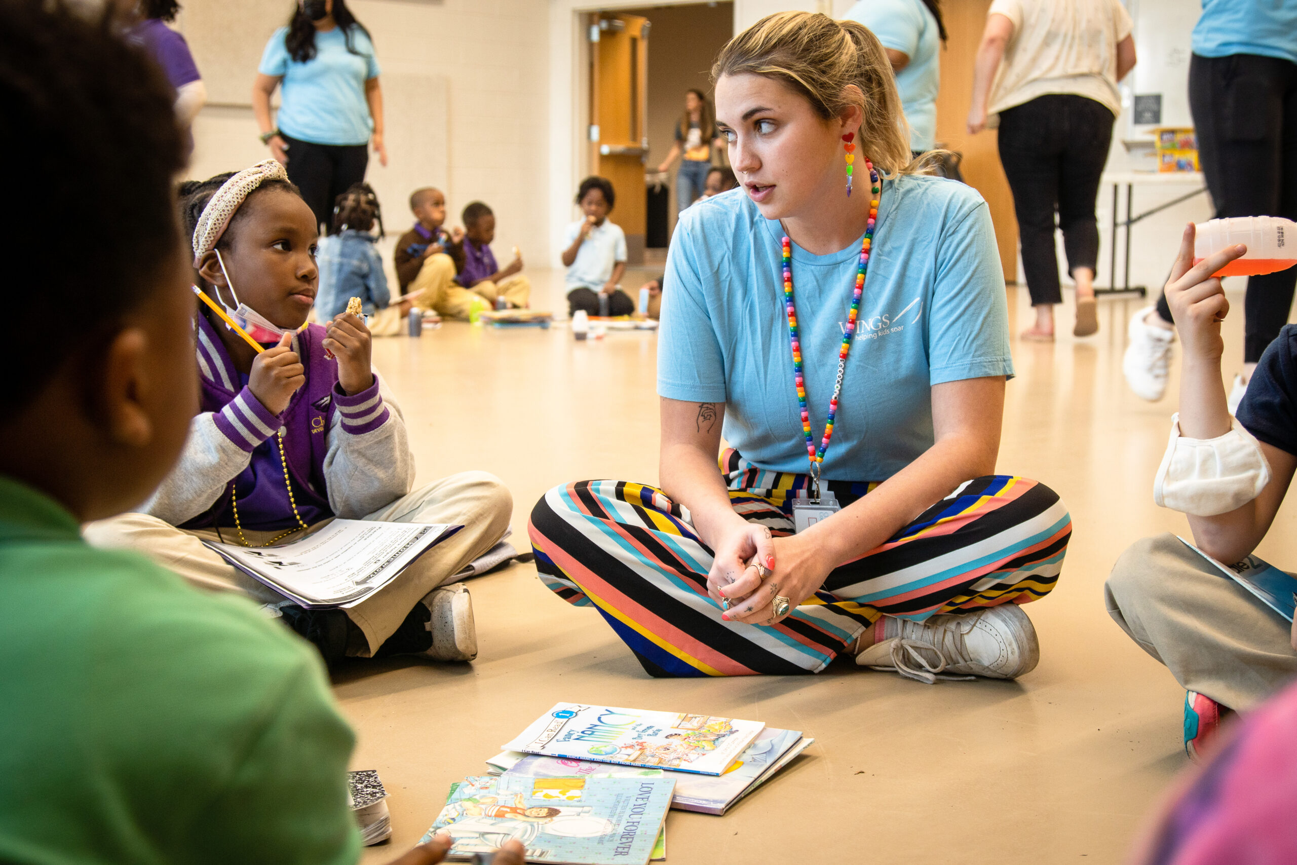 Future of Learning WINGS leader sits with kids